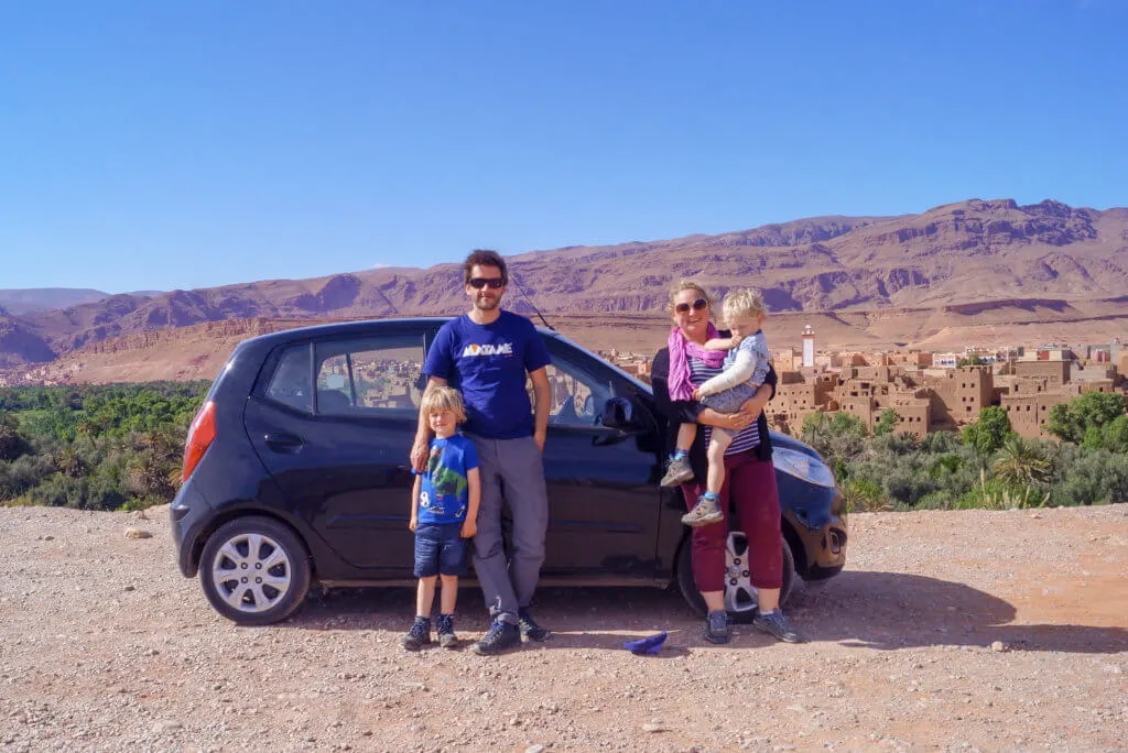 family stood by car in Morocco