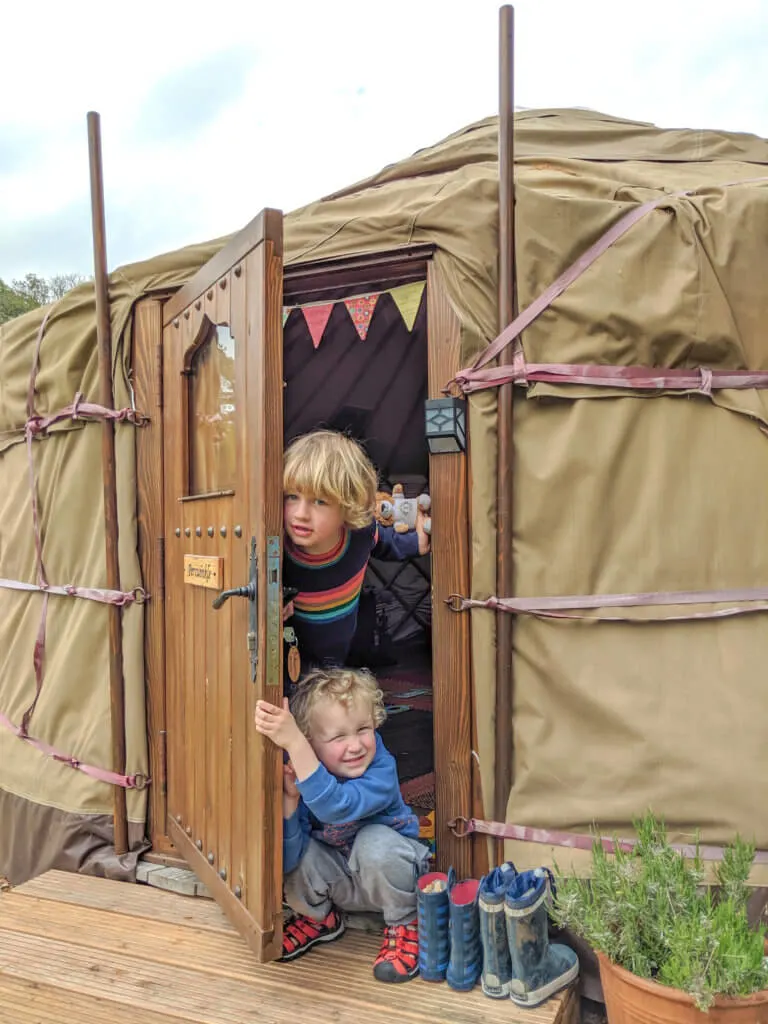 boys coming out of yurt door