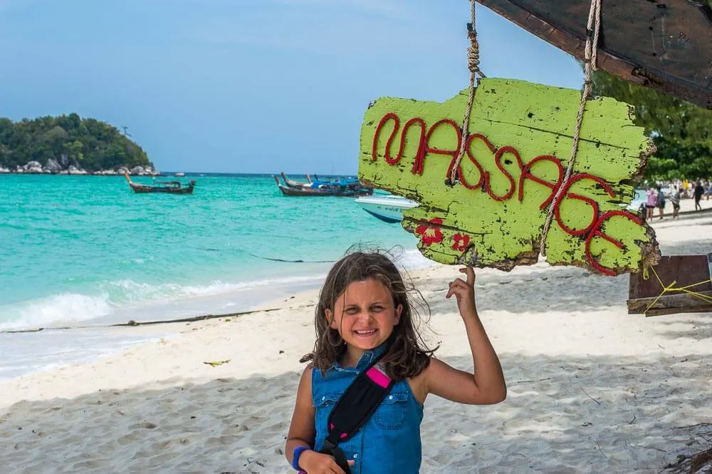 Child on beach by sign