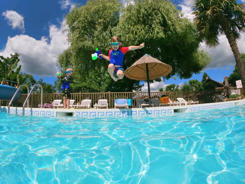 boy jumping in to swimming pool