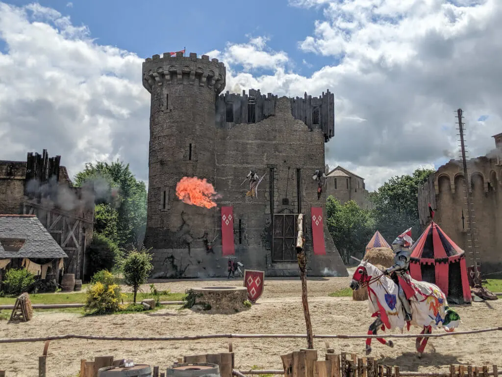 knight galloping past a castle on a horse