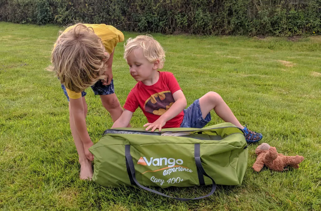 two boys opening tent bag