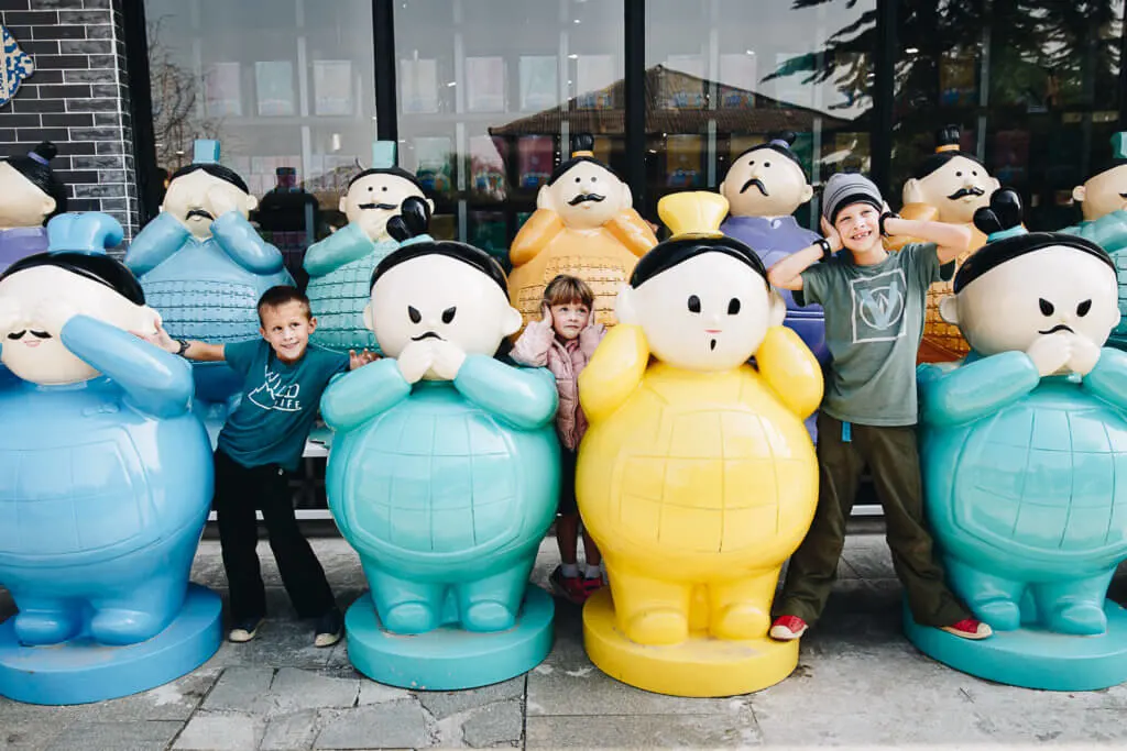 children playing in fun Chinese statues